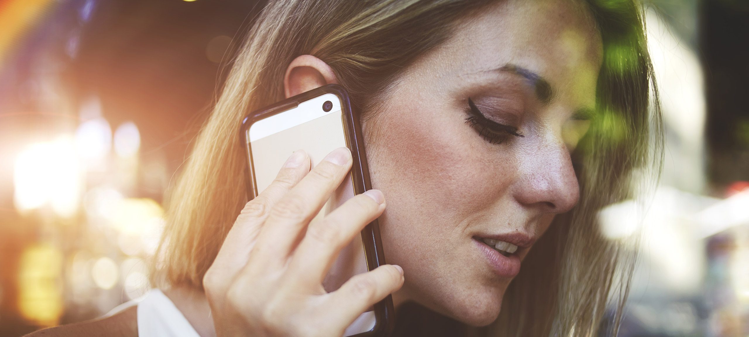 Une femme tient son téléphone à l'oreille